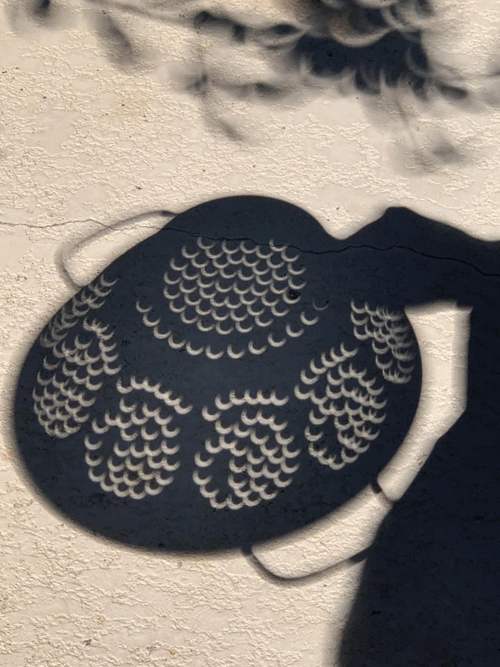 Eclipse through a colander's shadow by Michael Primm