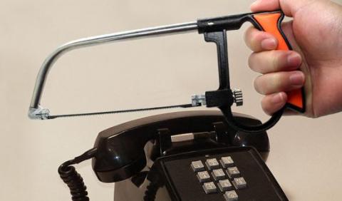 Image of someone using a saw to cut through a telephone