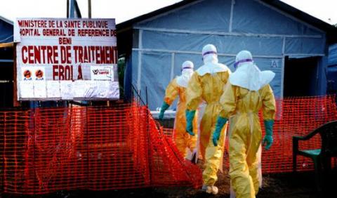 Men in hazmat suits entering a building